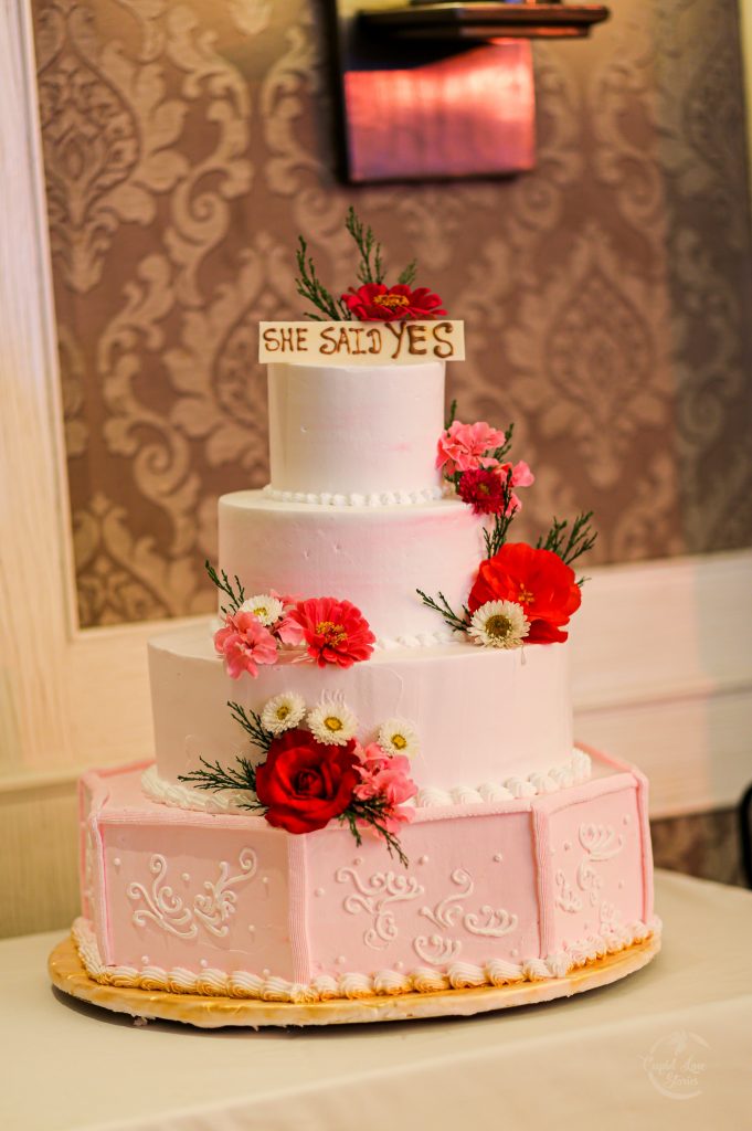 Aparna & Arnav's Pastel Peach Colored Floral Wedding Cake with a 'She Said Yes' Cake Topper