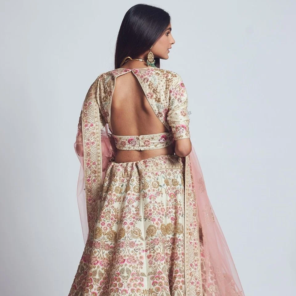 Backless blouse design for lehenga with pastel embroidery 