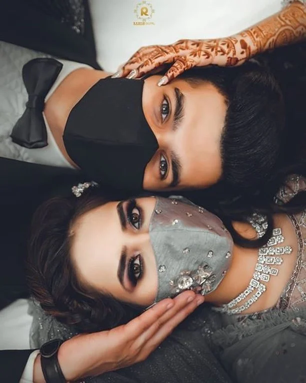 Indian couple posing with black and silver mask for intimate wedding
