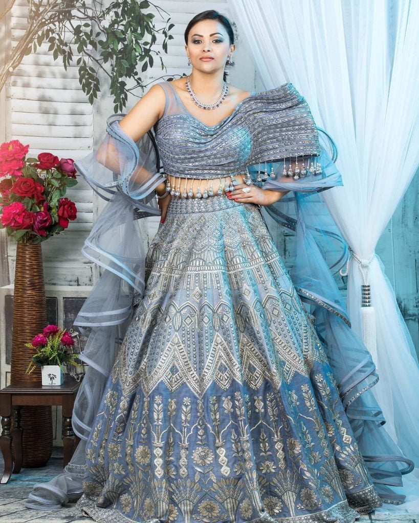 Pastel blue lehenga with an asymmetric blouse and tassel details 