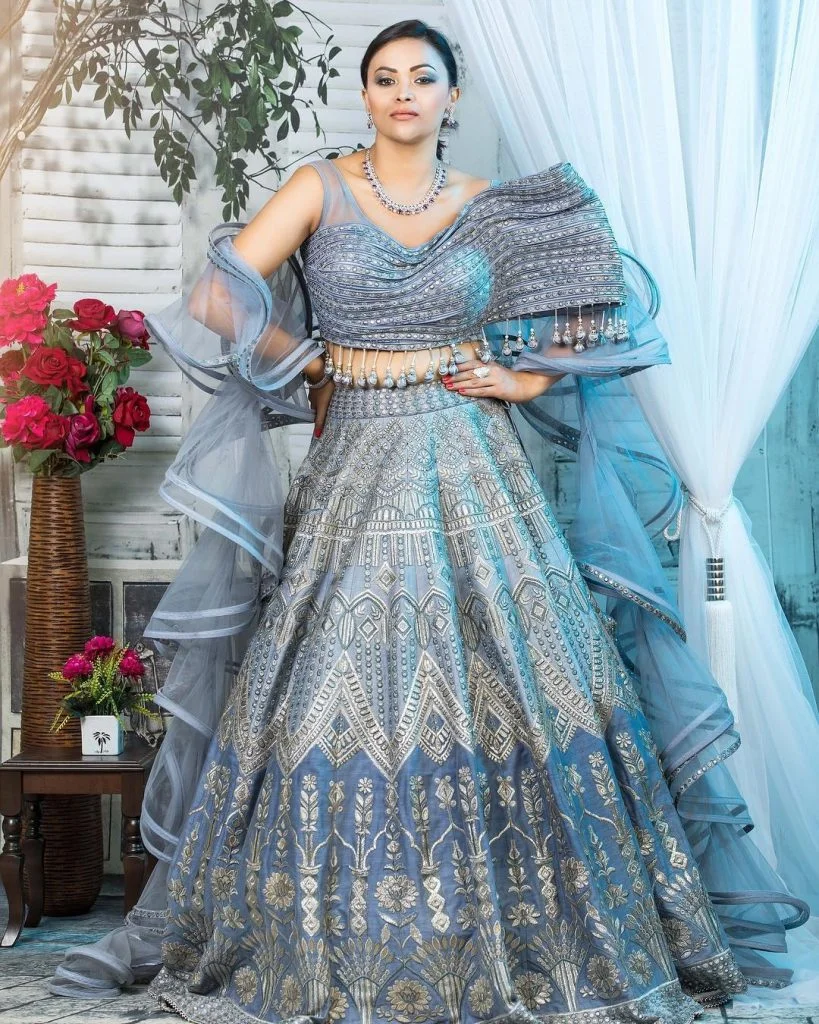 Pastel blue lehenga with an asymmetric blouse and tassel details 