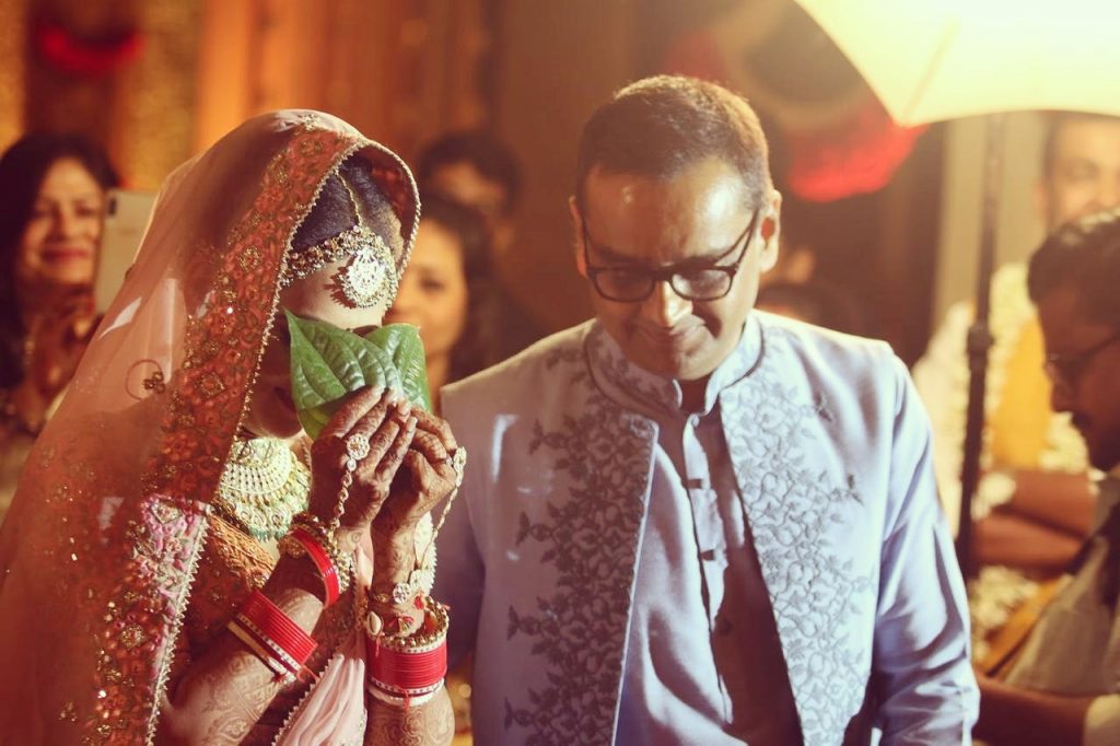 Marwari bride with Bengali entry holding green betel leaves