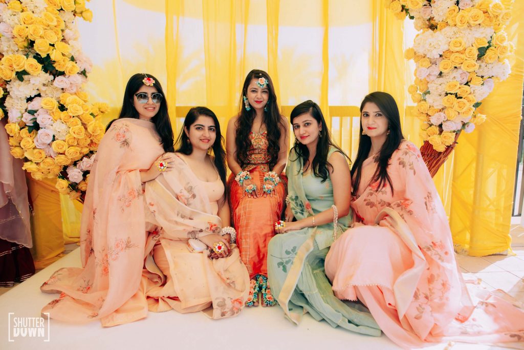 Picture of Mrighna & Bridesmaids in coordinated pastel outfits in Shades of Sunrise themed haldi ceremony for this beach wedding in Dubai 