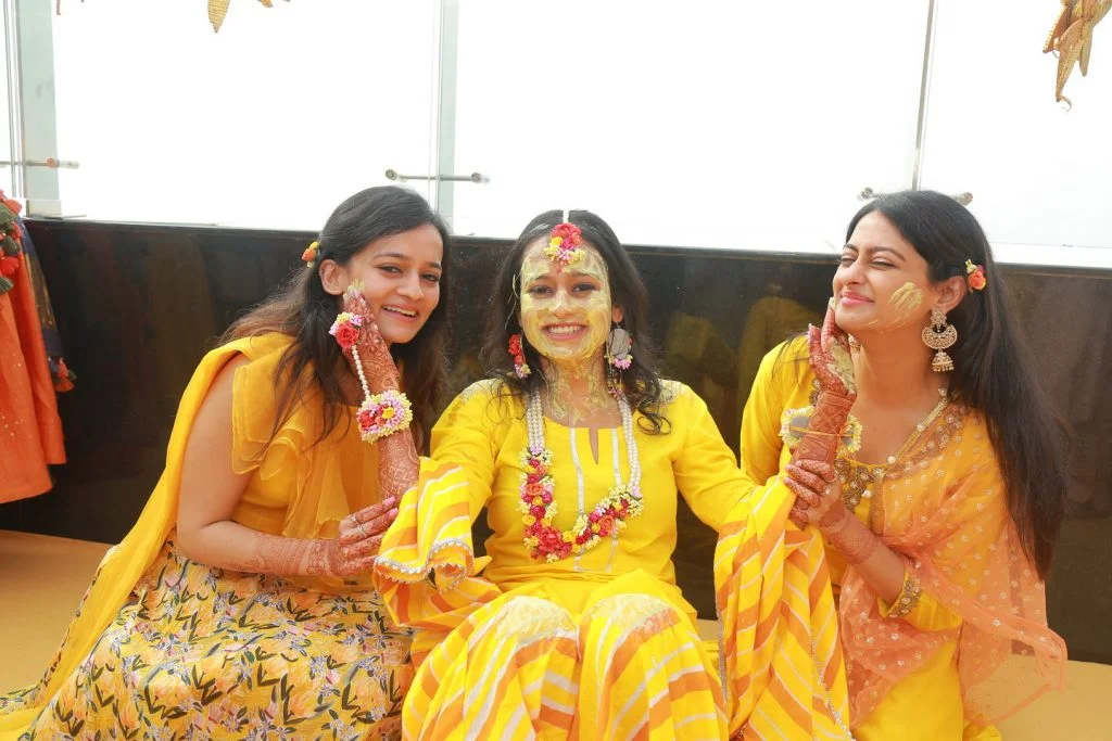 bridesmaid and bride in yellow kurta and multicolour flower jewellery