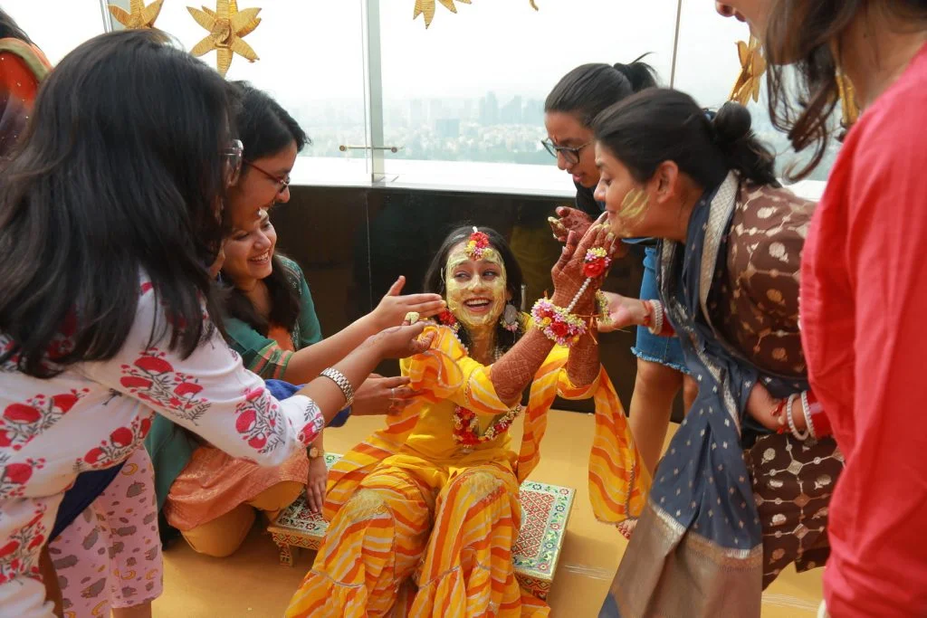 candid of bride and family laughing in fun haldi ceremony