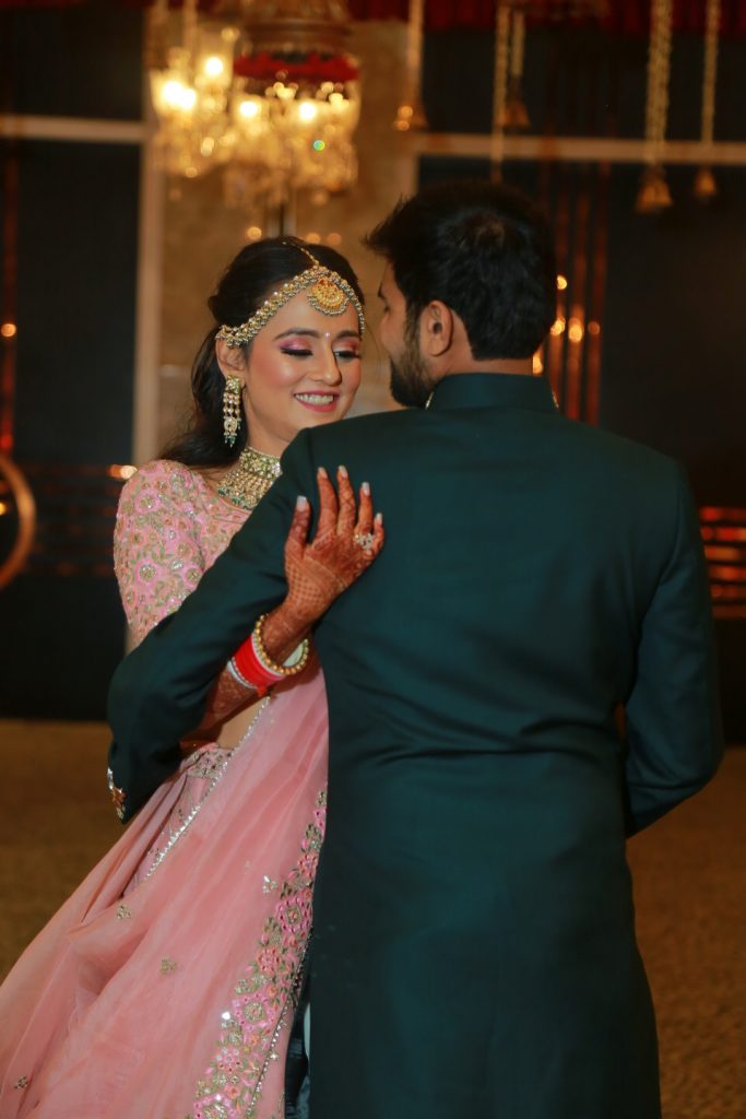 indian bride posing with groom in dark green kurta for reception