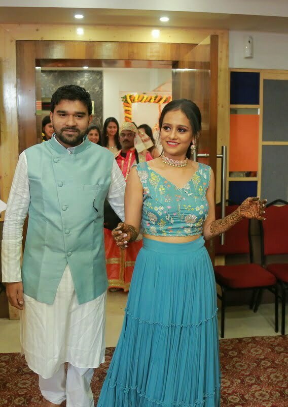 couple in blue matching attire with bride in floral blue crop top and white peach choker