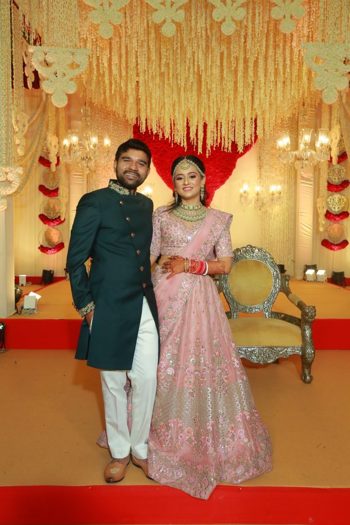 portrait of bride in pink lehenga and groom in dark kurta for reception