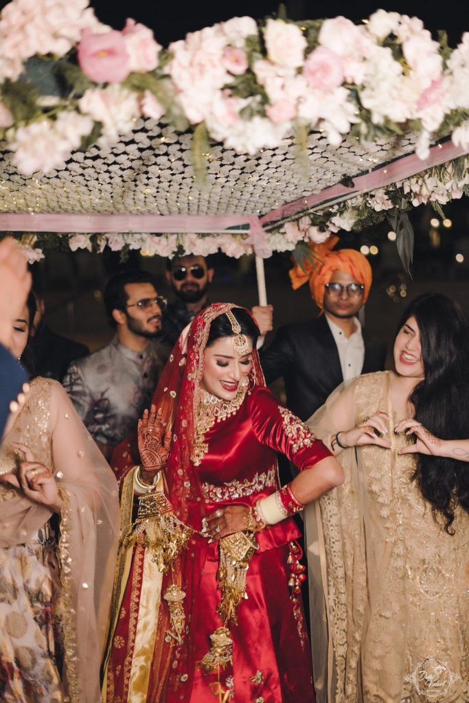 dancing beach wedding bridal entry in traditional red lehenga and phoolon ki chadar