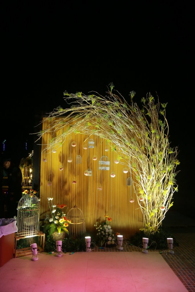 golden drapes, lighting and plants for a simple engagement stage