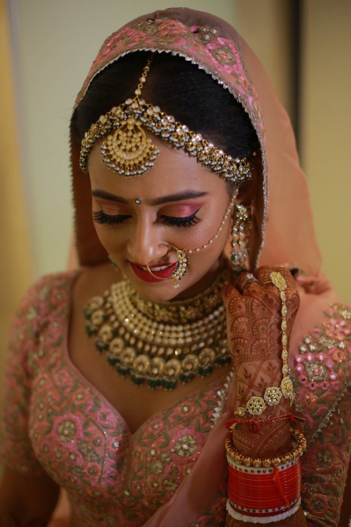 indian bride in onion pink lehenga, light makeup and jewellery