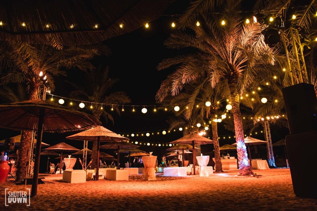 welcome dinner in outdoor destination beach wedding with round string lights