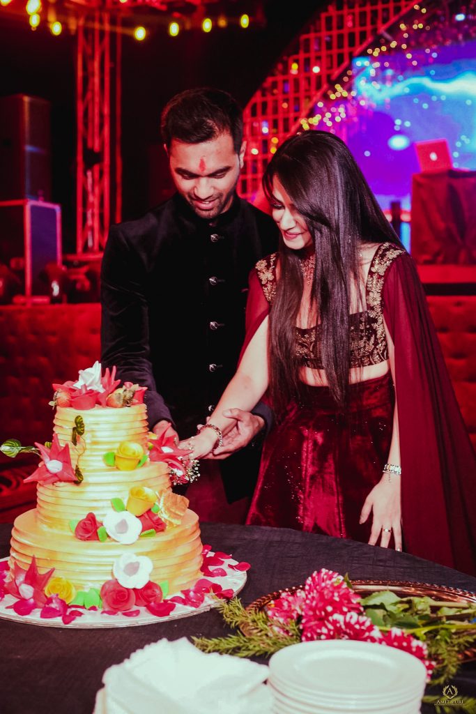 Candid of couple cutting three tier cake for pre wedding reception