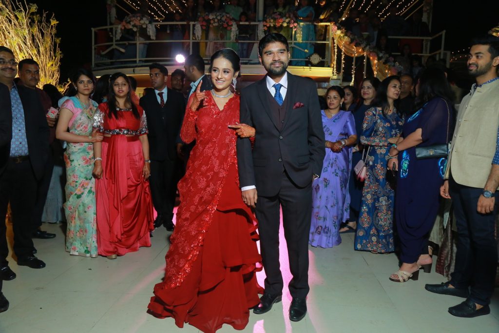 bride in a red shimmery lehenga with silver necklace and earrings