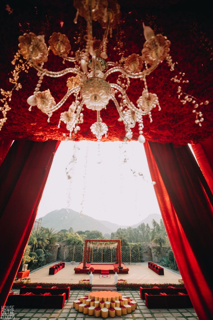 golden chandelier and red themed open stage decoration for haldi