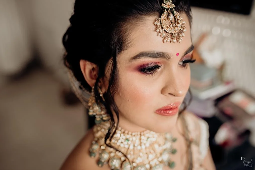 Indian bride in rosewood pink smokey eye makeup and glossy nude lipstick