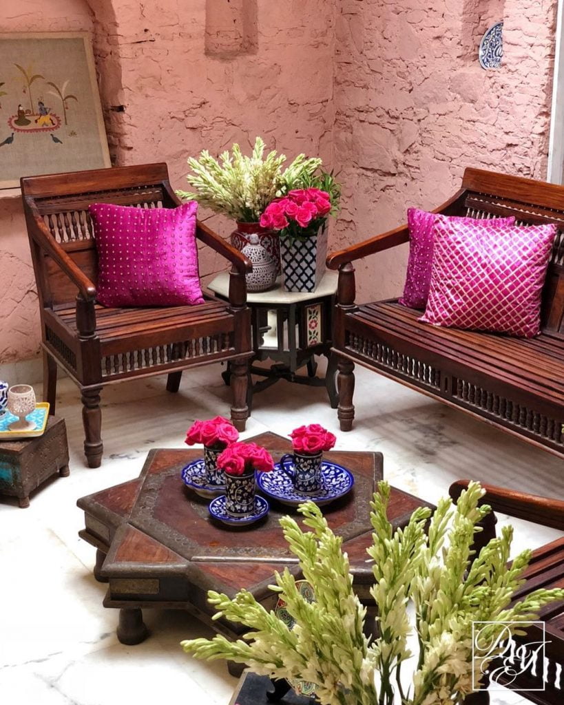 bright pink pillow covers on brown benches for wedding decoration