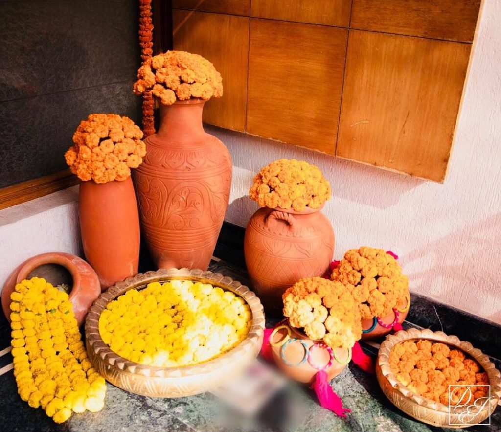 brown clay matka earthenware with marigold for Indian wedding home decoration