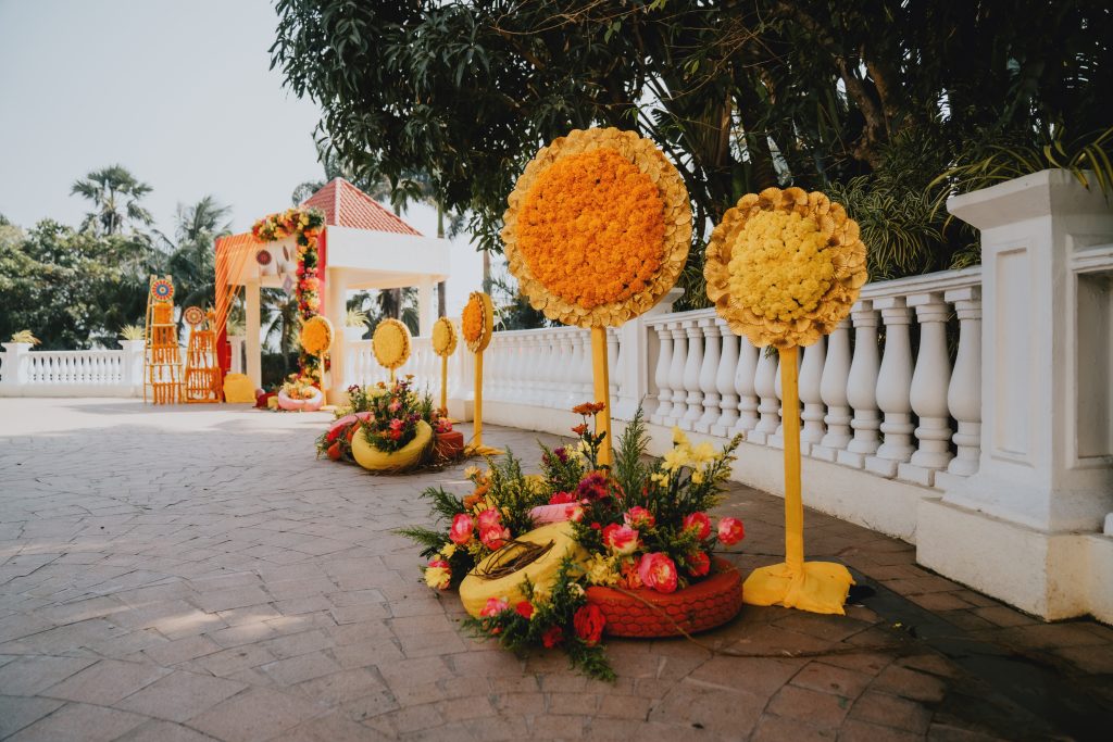 yellow and red rustic painted DIY tyres decor with flower bushes for wedding