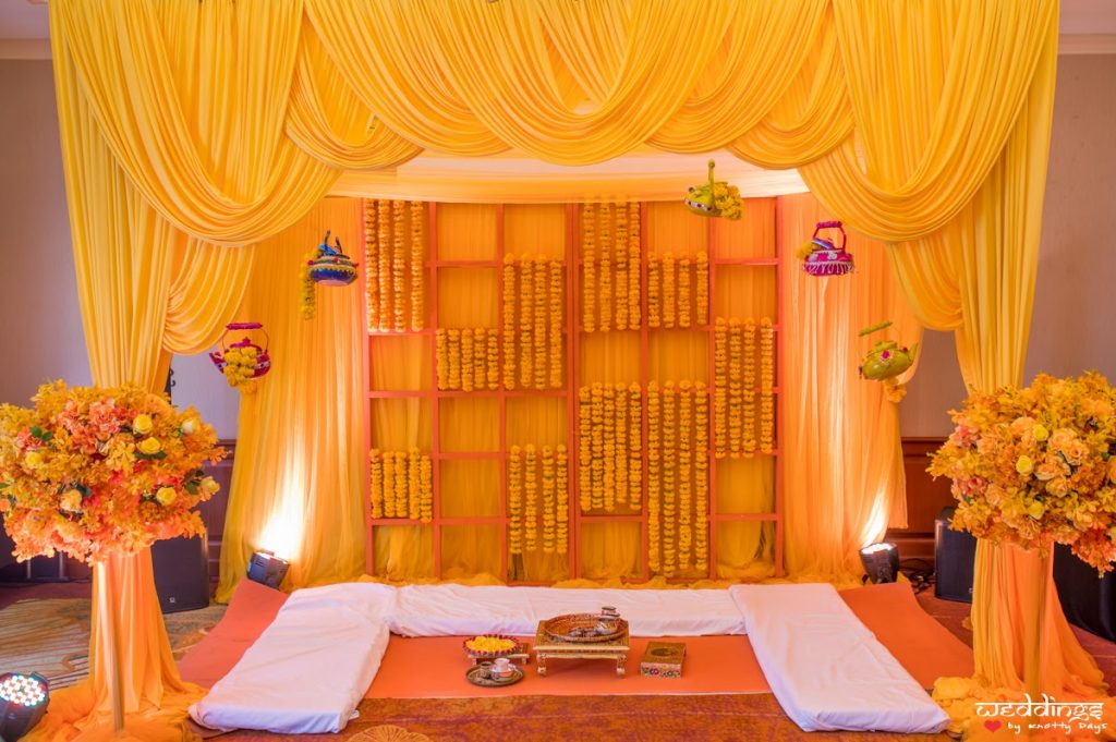 Simply stunning decor with yellow drapes, floral and pot hangings for this Dusit Thani Hua Hin Wedding's Haldi Ceremony