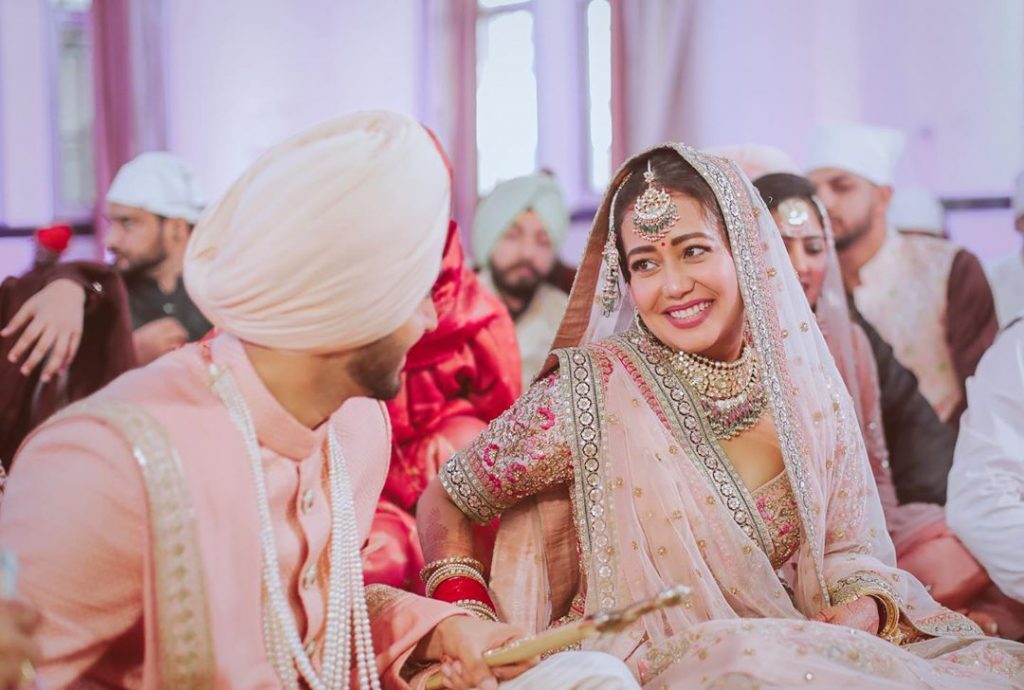 Neha kakkar in a pastel pink sabyasachi lehenga and rohanpreet in a matching pastel pink sherwani for their anand karaj wedding ceremony in delhi