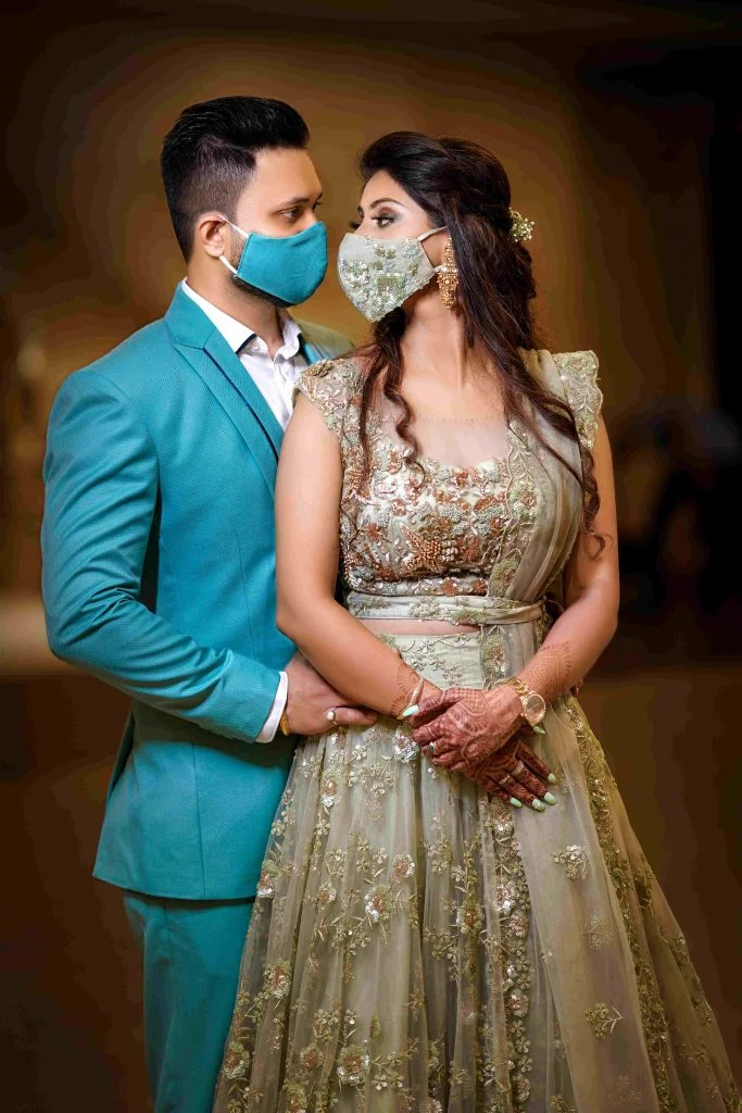 Bride and Groom in blue & olive green wedding face masks coordinated with their respective outfits