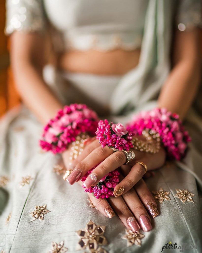 pink and golden glitter indian bridal nail art with pink flower haldi jewellery