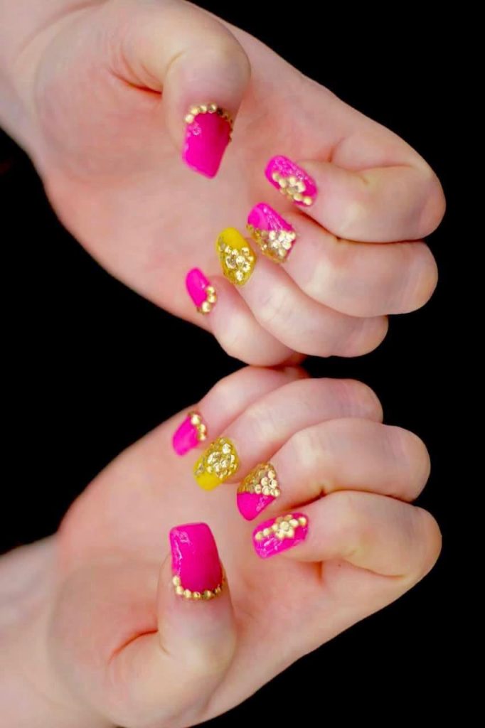 bright hot pink nails with golden jewels