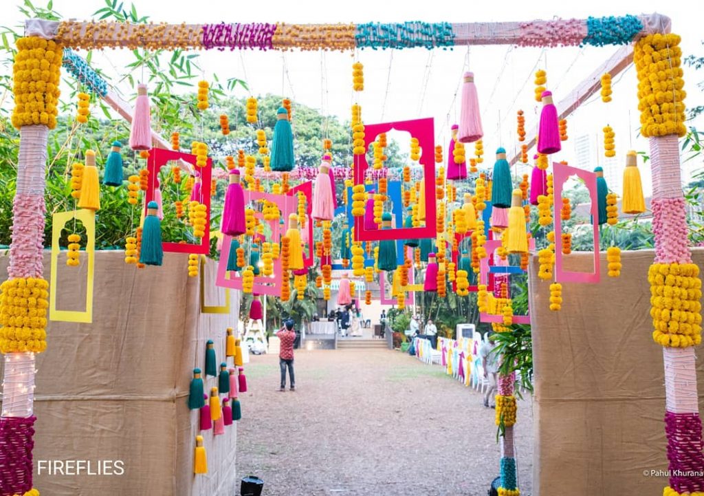 colorful hanging DIY tassel, frames and marigold wedding decor