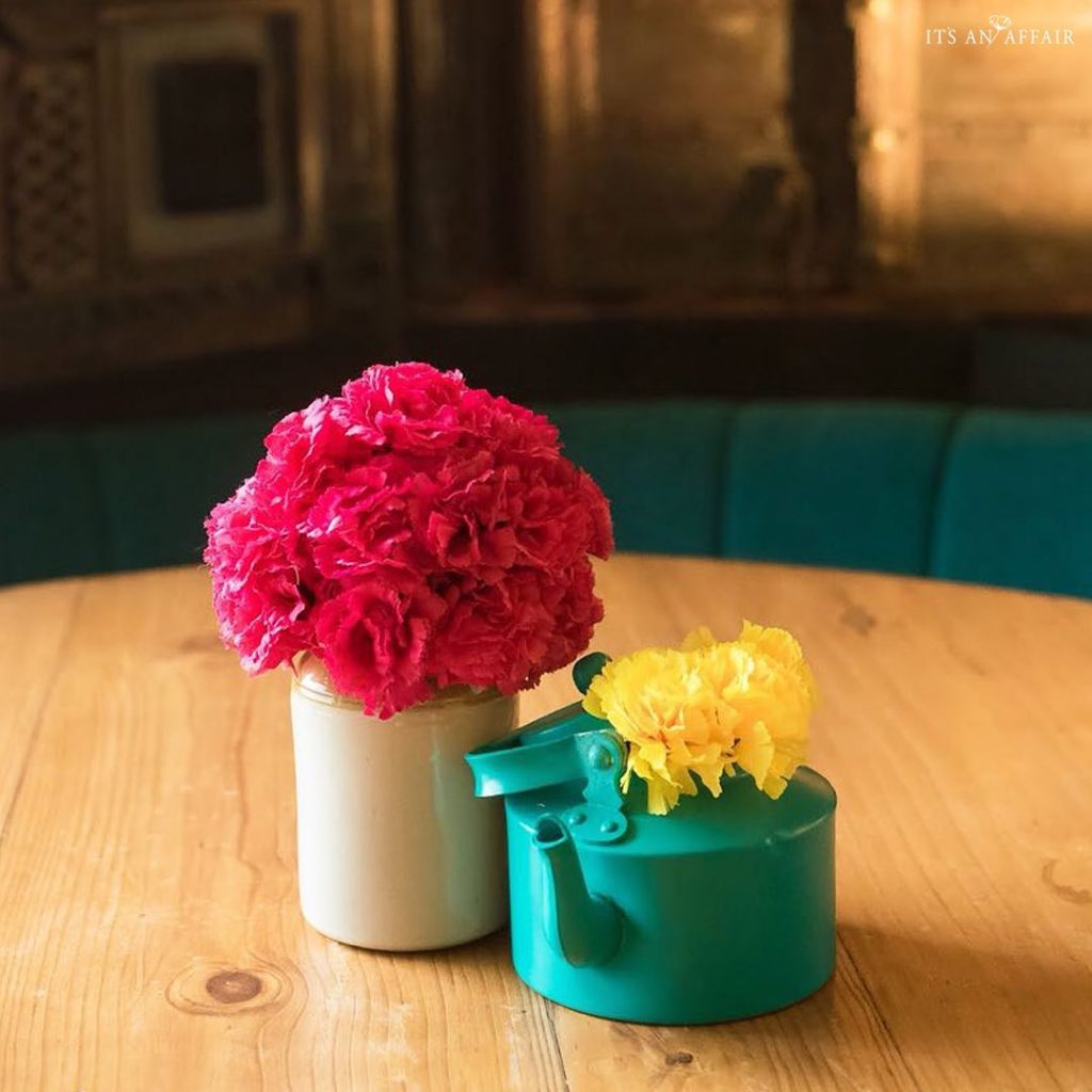 blue kettle with dainty yellow flowers and mason jar with pink roses