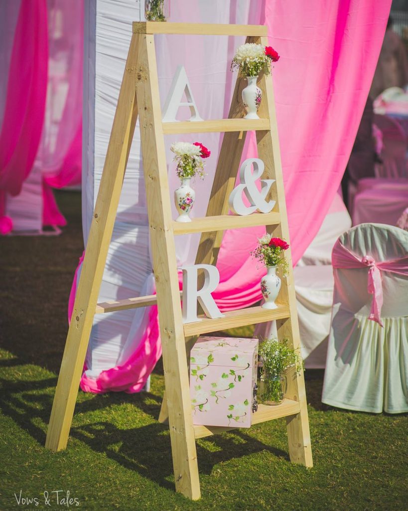 beige ladder wedding decor with flower vases