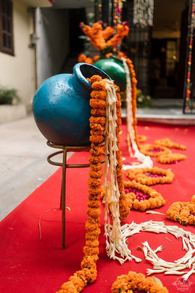 blue painted matka earthenware with flowing marigold strings