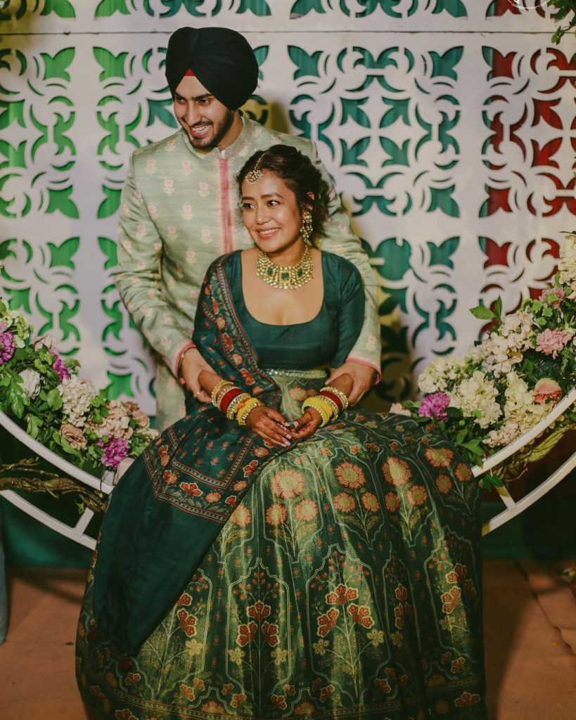 neha kakkar in green anita dongre floral mehendi lehenga with golden emerald jewelry 