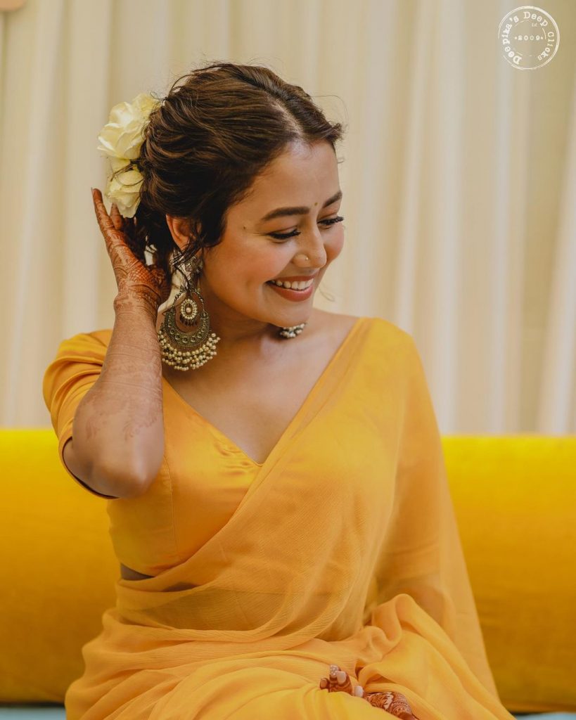 sheer yellow haldi ceremony neha saree with hair bun and beaded chandbali earring 
