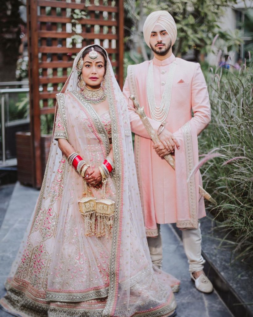 neha kakkaar and rohanpreet in pastel color coordinated sabyasachi outfit for phera and jaimala ceremony
