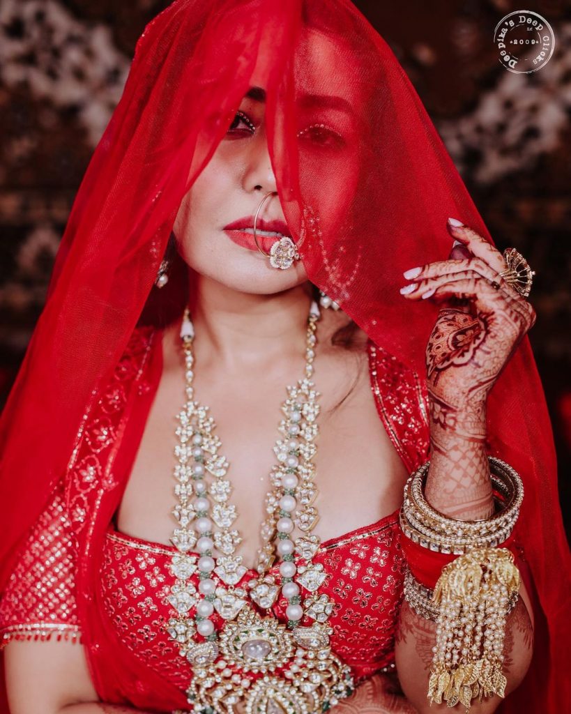 neha kakkar posing with heavy wedding jewellery and golden kaleera