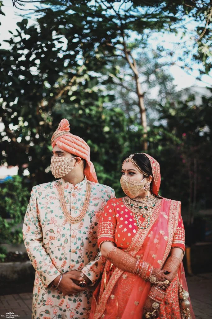 couple in coordinating pastel silk face masks with patterned zari embroidery