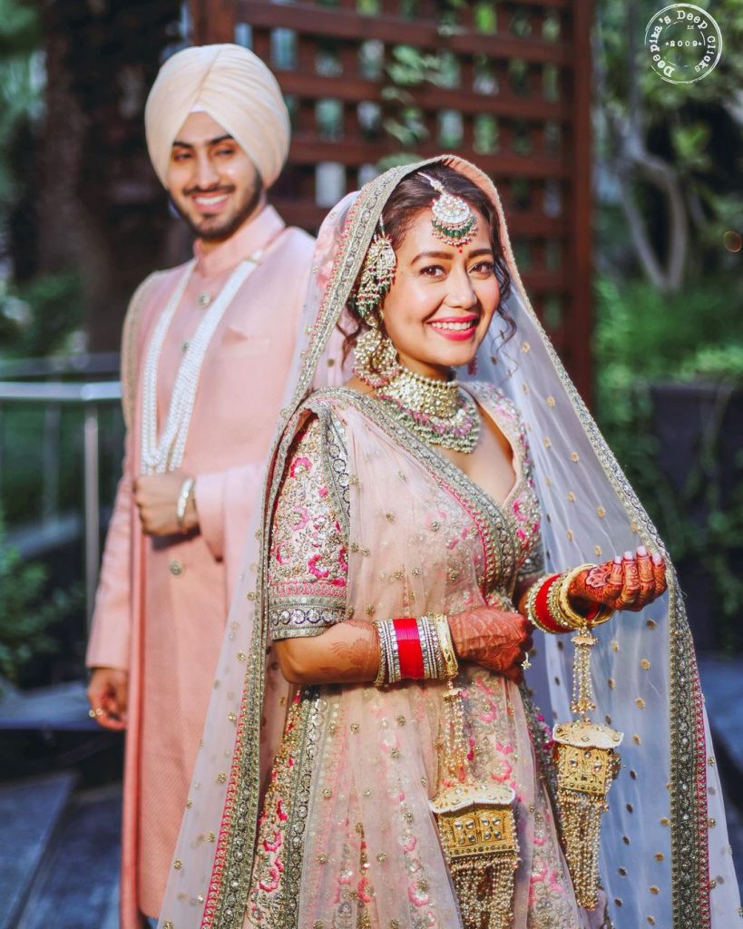 neha kakkar emrboidered heavy day ceremony pastel pink sabyasachi lehenga