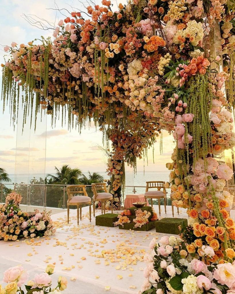 beachside mandap with lots of flowers and foliage