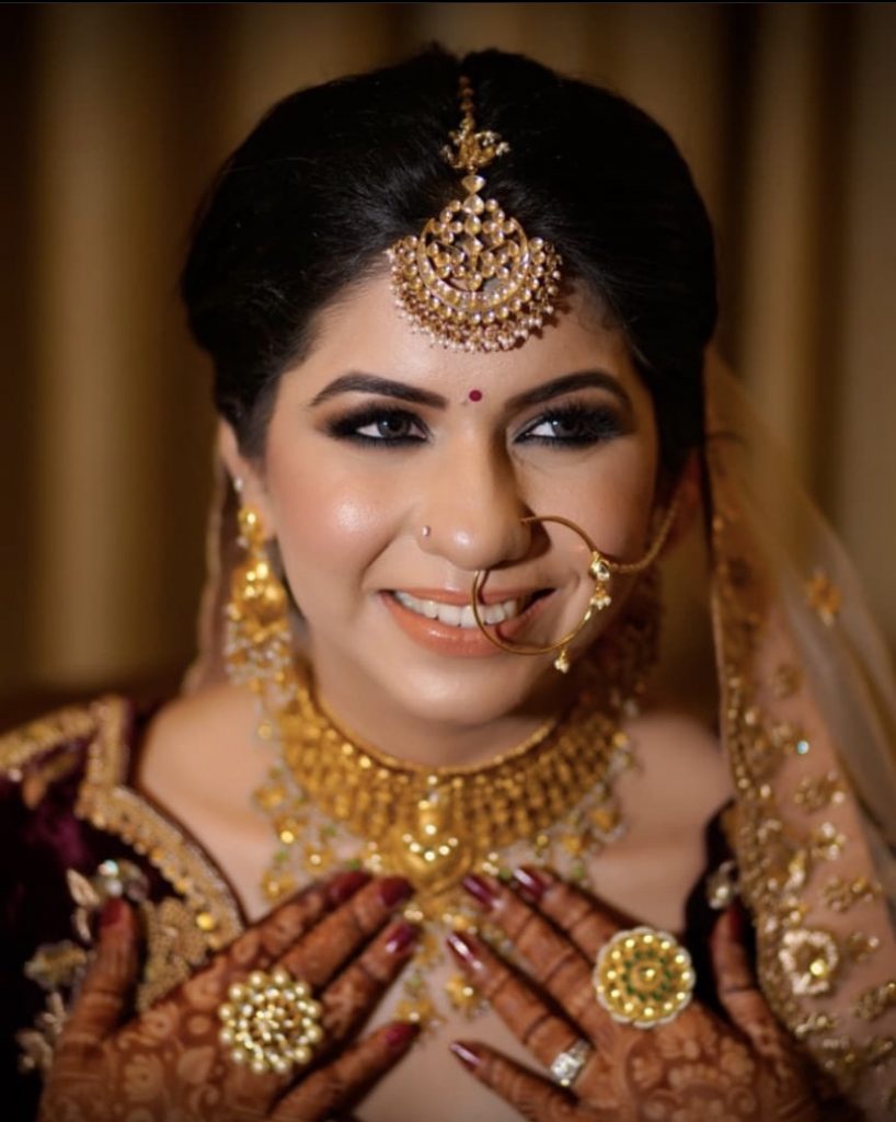 maroon bridal lehenga with gold jewellery