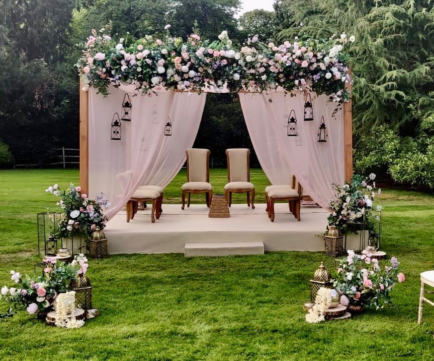 garden mandap decor with peach flowers and lanterns