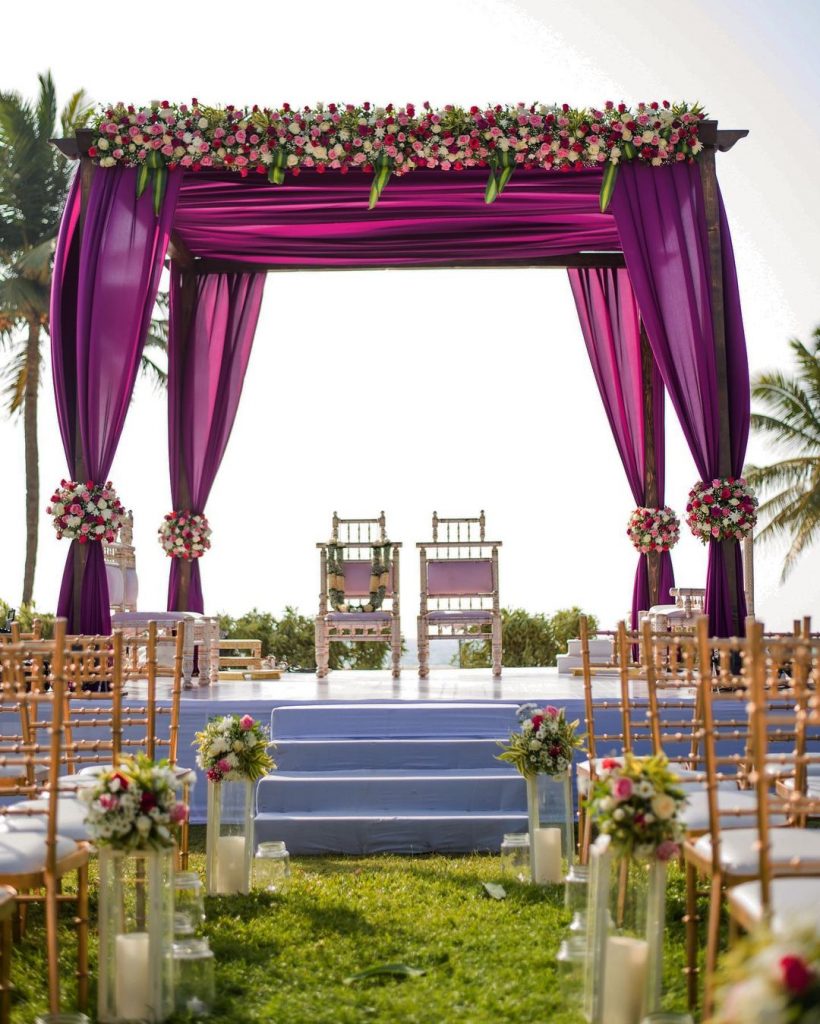 simple outdoor mandap with violet drapes and flowers