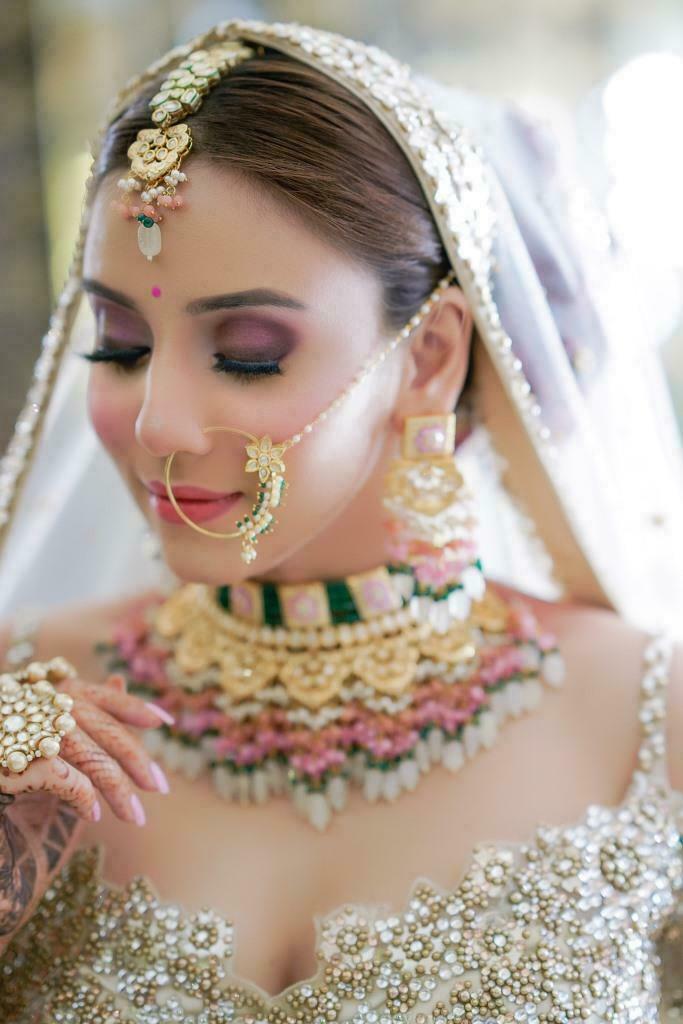 bride defining her eyelashes with mascara from her bridal makeup kit box