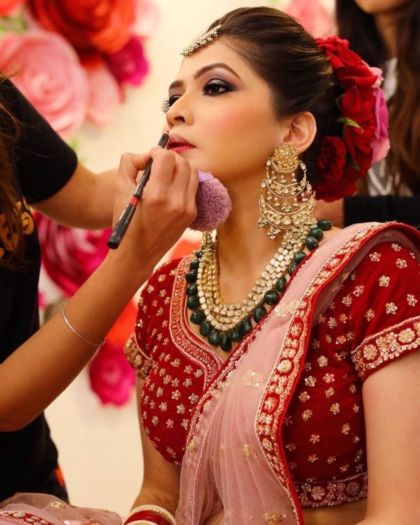 bride getting her lips lined with a lip liner which is a top makeup product in her bridal kit