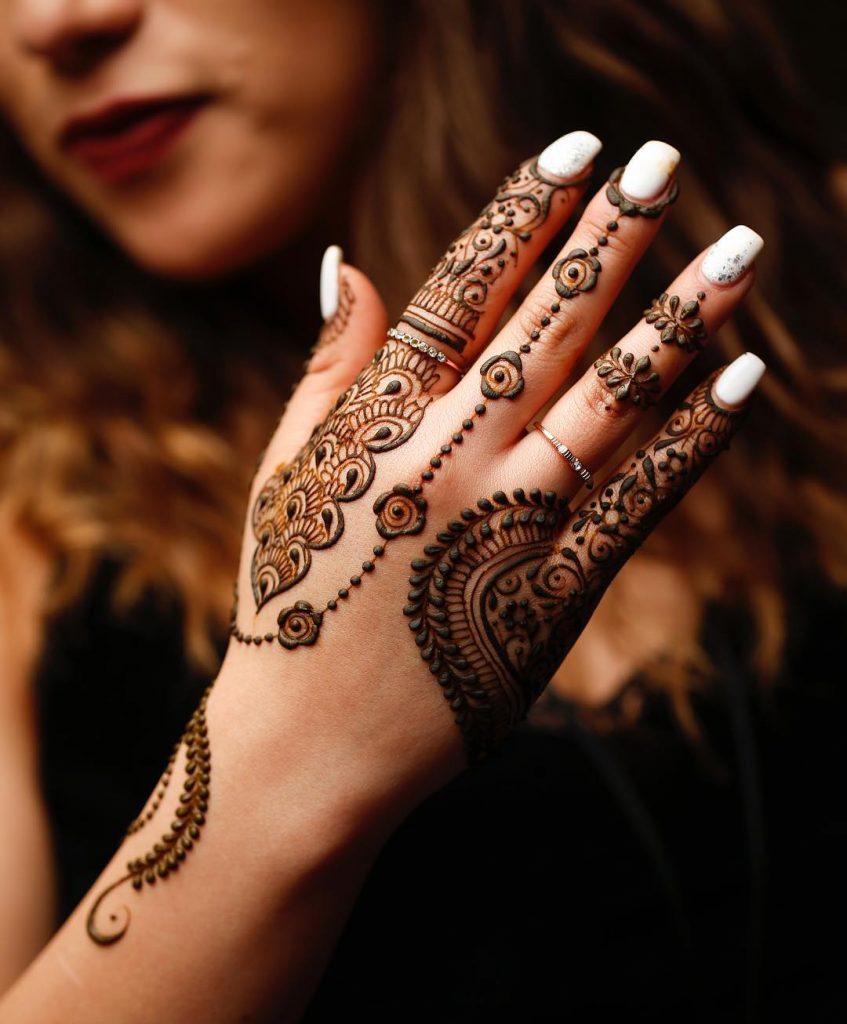 Minimalistic back hand mehendi with string motifs