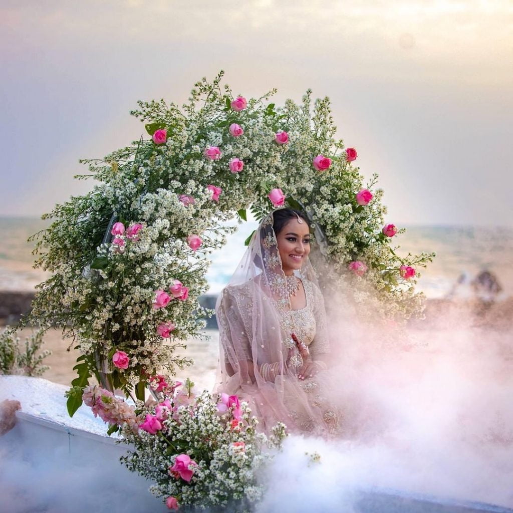 bridal entry in boat decked with floral wreath