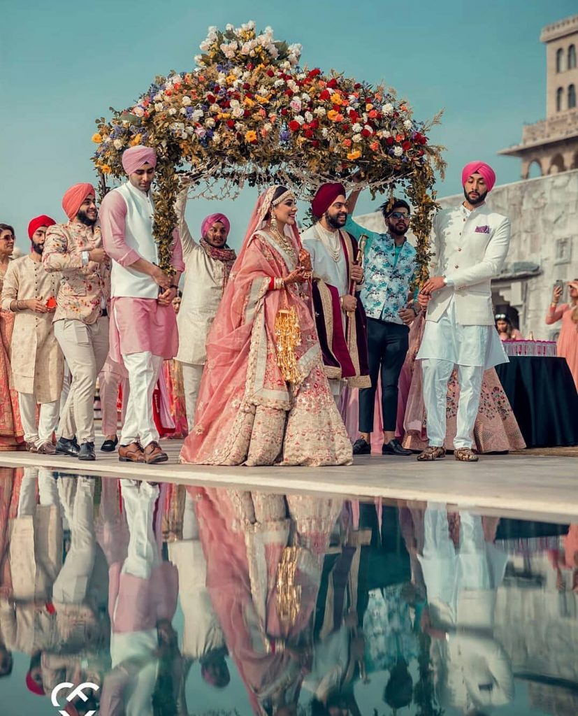 wedding entry idea for bride under an umbrella shaped floral canopy