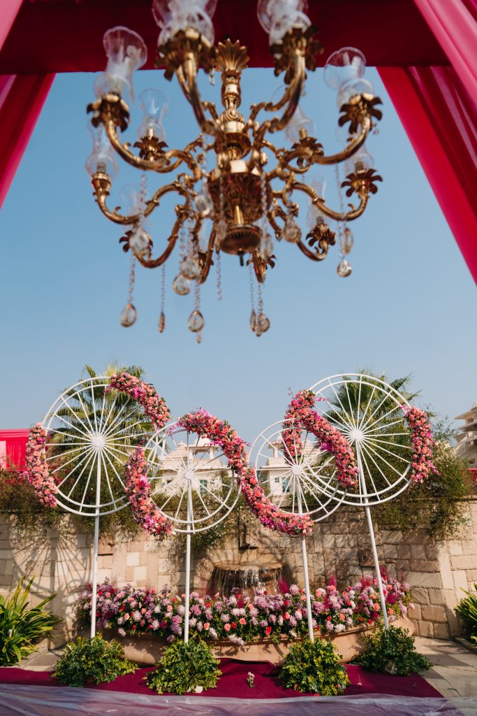 Floral outdoor Decor with pink flowers and cycle wheels for mehndi function