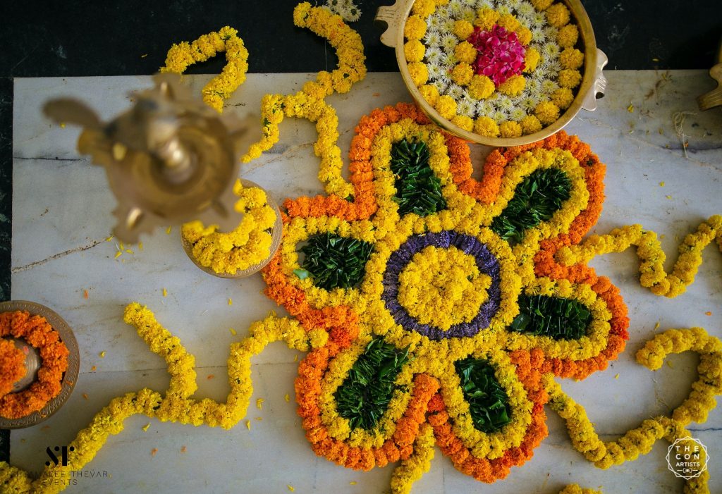 Indoor decoration with mogras, marigolds and vines accessorized with gold accessories