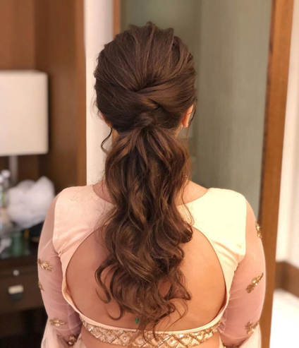 bride in a low ponytail as a bridal hairstyle for round face